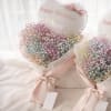 Two pastel baby’s breath bouquets with pink ribbons and birthday balloons