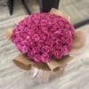Large bouquet of pink roses wrapped in brown paper