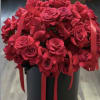 A lush dome of vivid red roses packed tightly into a matte