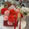 A clustered display of red roses, pink carnations, white daisies and pale