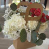 Large white hydrangea blooms paired with clustered red roses create an immediate