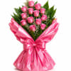 A bouquet of gorgeous pink roses wrapped in pink paper makes a