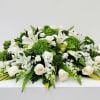 A calm, formal spread of white roses and lilies set against vivid