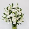 A serene cluster of white lilies, roses, chrysanthemums and tall snapdragon spikes