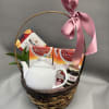 White teapot and assorted teas in a round wicker basket with a