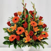 Bright red roses, orange gerbera and lilies arranged full and upright in