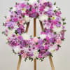 Large circular wreath of mixed pink, lavender, purple, and white blooms on