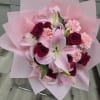 Pink lily and red rose bouquet wrapped in pale pink paper