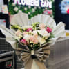 Bouquet of pink and white roses wrapped in white and beige paper