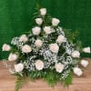 White rose arrangement with baby's breath on a green backdrop