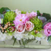 Pink and green floral arrangement in a clear rectangular vase