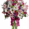Bouquet of pink roses and white daisies in a clear glass vase with a magenta ribbon
