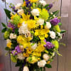 Standing floral spray with yellow, white, and purple flowers