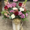A decorative pitcher with fresh bloom with color and style of your