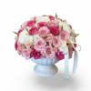 A soft, romantic arrangement of blush and pink roses paired with delicate