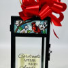 Black lantern with a red bow and a candle reading Cardinals appear when angels are near