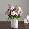 Soft lavender stock and crisp white roses mingle with lavender alstroemeria in