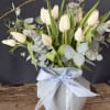 Elegant white tulips with soft eucalyptus and natural branches, beautifully arranged in
