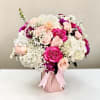 Lush pink and white roses mingle with voluminous white hydrangeas and delicate