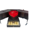 Red roses in a black heart-shaped box with chocolates in a drawer below.