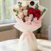 Bouquet of red and pale pink roses wrapped in white paper