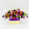 Lavender and orange roses mingle with deep purple accents and tiny yellow