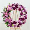 A lush circular wreath in shades of pink, purple, white, and green