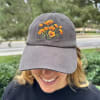The cap features high quality embroidered orange poppies with dark stitched stems