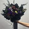 Bouquet of dark red roses and purple lisianthus with black wrapping
