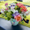 Coral-pink and orange-pink roses take center stage in this Santorini flower arrangement