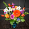 A bright, cheerful bouquet centered on a bold orange gerbera daisy-this mixed-color