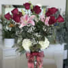 Tall red roses rise above soft pink lilies in a romantic birthday