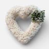 Heart-shaped floral wreath of white roses and pale blooms