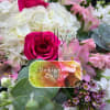 Bright arrangement with hot pink roses, white hydrangeas, and assorted pink flowers.