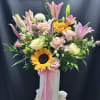 Sun-kissed sunflowers and tall pink lilies give this upright mixed flower arrangement
