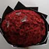 100 roses arranged into a round bouquet with the color paper of