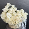 White roses and anthuriums arranged in a wicker basket with ribbon
