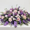 Soft lavender and blush come together in a low, broad floral design