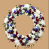 A formal circular wreath of deep red roses, snowy white chrysanthemums and