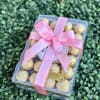 A glossy clear plastic gift box tied with a wide pink ribbon