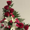 Tall red roses lift the eye above clusters of large white lilies