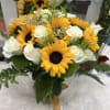 Bouquet of sunflowers and white roses in a glass vase