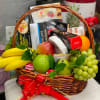 Gift basket with fruit and assorted snack boxes tied with a red ribbon