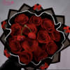 Bouquet of red roses wrapped in black paper with pearl trim and red bows