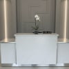 White orchid in a small square vase on a marble reception desk