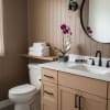 Purple orchid in a square glass vase on a bathroom counter