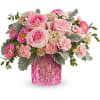 Pink roses, pink carnations, riceflower, and lavender pomps in a pink vase.