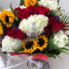 Bouquet of red roses, white hydrangeas, and sunflowers wrapped in clear plastic