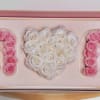 Two large pink rose letters flank a pure white rose heart in