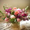Pink and coral roses arranged in a gold vase